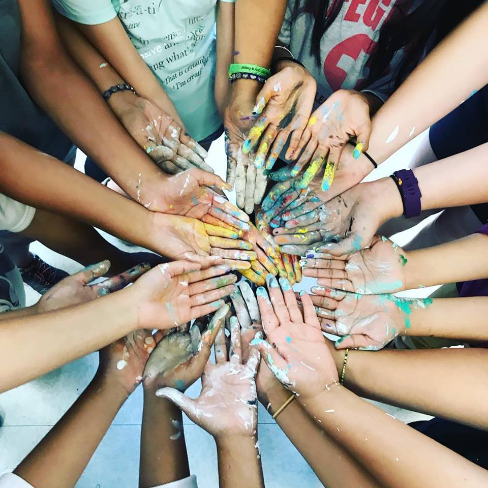 A group of people joining hands in a huddle. 