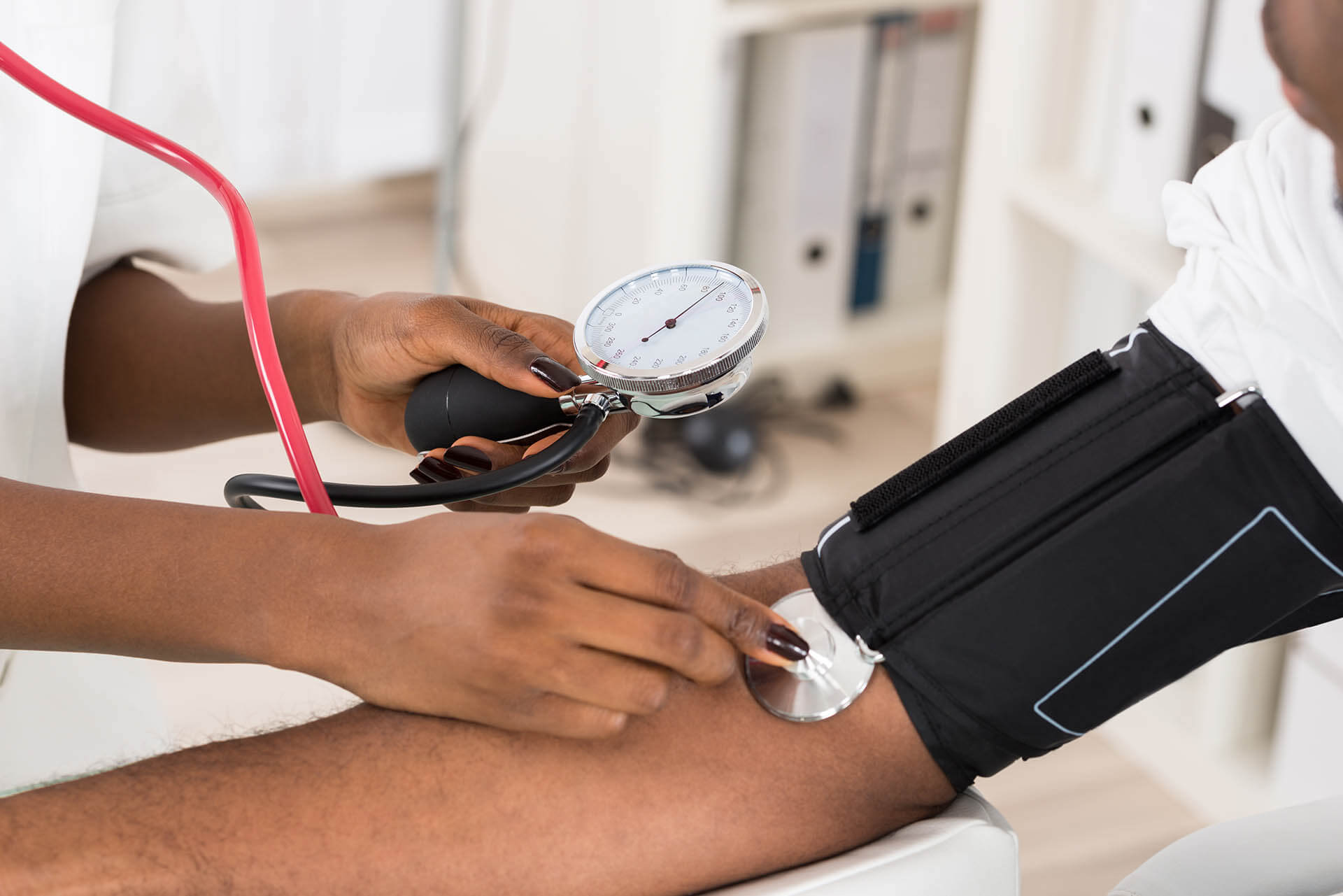 A patient getting their blood pressure checked by a nurse or doctor. 