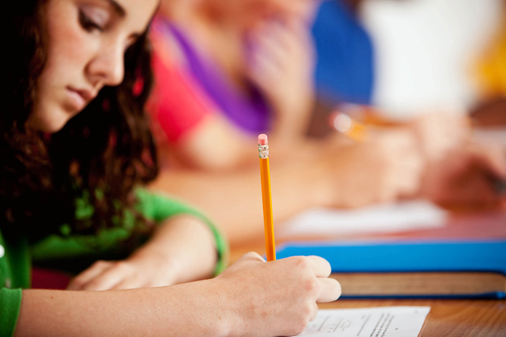 A young adult women taking a test in class. 