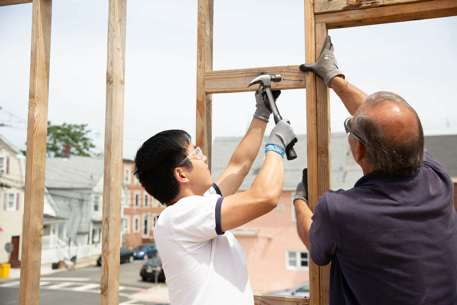 Two men setting up a wooden frame.